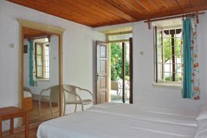 a bedroom with a bed and a table and chairs at Sotos pension in Skopelos Town
