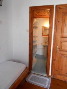 1 dormitorio con puerta que conduce a un baño en Sotos pension, en Skopelos Town