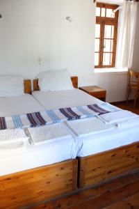 two twin beds in a room with a window at Sotos pension in Skopelos Town