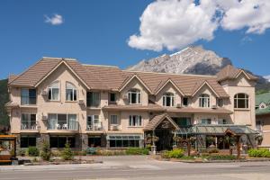 a large building with a mountain in the background at Irwin's Mountain Inn in Banff