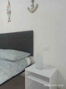 1 dormitorio con cama negra y mesa blanca en Casa Fuerte, en Laigueglia