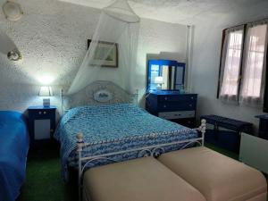 1 dormitorio con 1 cama con edredón azul en La terrazza sul lago, en Pella