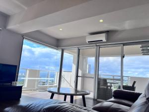 a living room with a couch and a table at Condominium Hotel Okinawa Yumeto - Vacation STAY 16578v in Nanjo