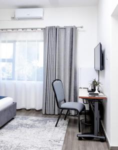 1 dormitorio con escritorio, ordenador y ventana en The Forty Four Hotel, en Lilongwe