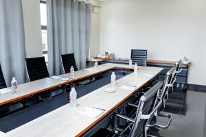 una sala de conferencias con mesas, sillas y botellas de agua en The Forty Four Hotel, en Lilongwe