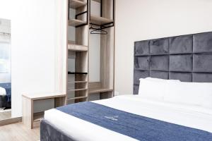 1 dormitorio con cama blanca y cabecero negro en The Forty Four Hotel, en Lilongwe