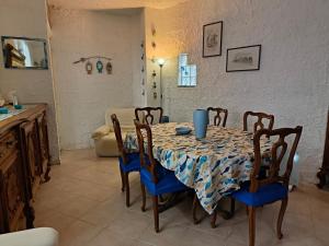 comedor con mesa con sillas azules y cocina en La terrazza sul lago, en Pella