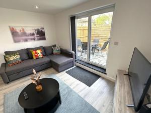 a living room with a couch and a tv at Elegant 2-Bed in Central Headington-Modern New Built Retreat- Wi-Fi, Netflix, Top Location in Oxford