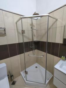 a shower with a glass door in a bathroom at Pombas Brancas Hotel in Mindelo