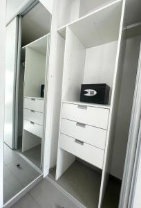 a white closet with white dressers and a mirror at Urbandeptomza in Mendoza