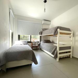 a bedroom with two bunk beds and a desk at Urbandeptomza in Mendoza