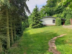 un patio con una casa al fondo en Ferienhaus Buchengrund mit eigenem beheizten Pool und Gegenstromanlage, en Sangerhausen