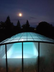 niebieskie światło na dachu budynku w nocy w obiekcie Ferienhaus Buchengrund mit eigenem beheizten Pool und Gegenstromanlage w mieście Sangerhausen