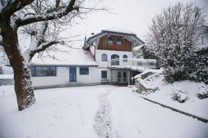 a house with a snow covered driveway in front of it at Ferienwohnung für 2 Personen im Bayerischen Wald in Neureichenau
