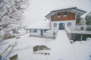 諾伊艾欣瑙的住宿－Ferienwohnung für 2 Personen ca 80 qm in Altreichenau, Bayern Bayerischer Wald，院子里的雪覆盖的房子