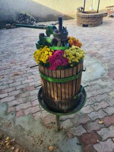 a water fountain with flowers in a wooden barrel at GERENDÁS VENDÉGHÁZ in Mátraderecske