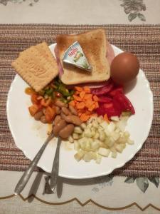 a plate of food with bread and vegetables on a table at Cozy hotel with breakfast in Subotica