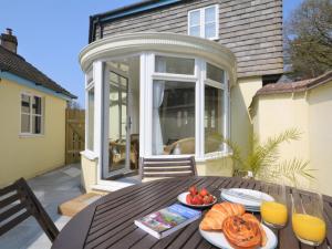 a table with a plate of food on a patio at 3 bed property in Bude HAPPY in Poughill