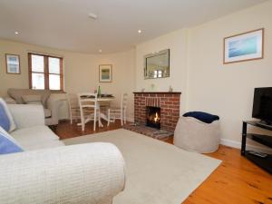 a living room with a couch and a fireplace at 3 bed property in Bude HAPPY in Poughill