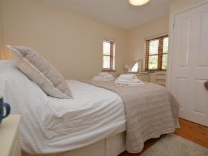 a bedroom with a bed with white sheets and pillows at 3 bed property in Bude HAPPY in Poughill