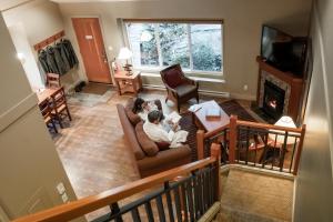 Long Beach Lodge Resort في توفينو: يجلس شخصان على أريكة في غرفة المعيشة