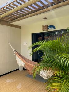 a hammock in a room with a plant at Vila Hayô in Passo de Camarajibe