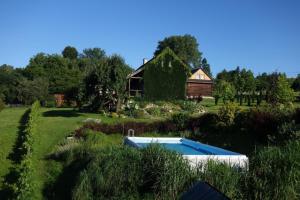 a garden with a swimming pool in front of a house at Ferienhaus in Cisowa mit gemeinschaftlichem Pool, Garten und Grill und Panoramablick in Cisowa