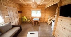 un soggiorno con divano e tavolo in una cabina di Wohnung in Paprotno mit Grill, Garten und Terrasse a Gąski