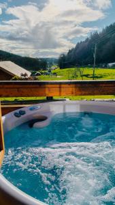 a hot tub with blue water and a fence at Bothy Cabin -Log cabin in wales - with hot tub in Newtown