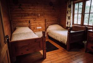 a bedroom with two beds in a log cabin at Bothy Cabin -Log cabin in wales - with hot tub in Newtown