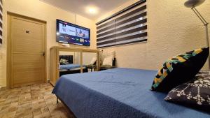 a bedroom with a bed and a flat screen tv at Appartement neuf au cœur de Quatre Bornes in Quatre Bornes