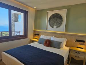 1 dormitorio con 1 cama y vistas al océano en Yialasi Hotel en Ancient Epidavros