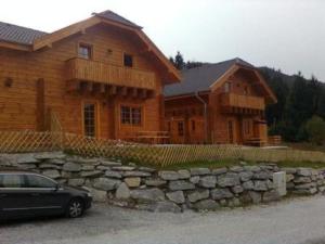 a black car parked in front of a wooden house at Skihütte Almhütte Tschaneck in Sankt Margarethen im Lungau