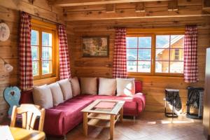 a living room with a couch in a log cabin at Skihütte Almhütte Tschaneck in Sankt Margarethen im Lungau