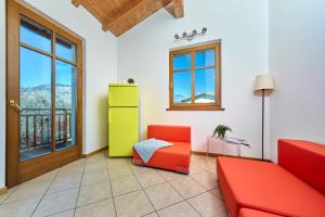 a living room with a red couch and a yellow cabinet at A Casa di Anna Maria in Brenzone sul Garda