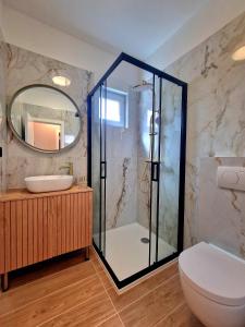 een badkamer met een douche, een toilet en een wastafel bij Villa Lumino in Murter