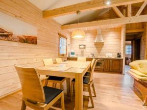 a kitchen and dining room with a wooden table and chairs at Charmantes Ferienhaus in Dbina mit Offenerem Kamin und Strand in der Nähe in Debina