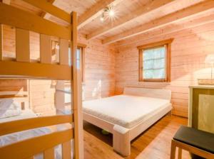 a bedroom with a bunk bed in a wooden cabin at Charmantes Ferienhaus in Dbina mit Offenerem Kamin und Strand in der Nähe in Debina