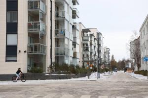 une personne faisant du vélo devant un bâtiment dans l'établissement New Apartment HILLA near all the main city spots Public car parking, à Rovaniemi 1 autre photo