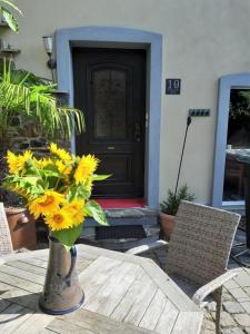 um vaso de flores amarelas em uma mesa em frente a uma porta em Wellness-Ferienhaus mit Privat-Spa em Gappenach