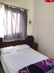 a bedroom with a bed with a window and a bedspread at Oceana surf house in Imsouane