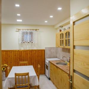 a small kitchen with a table and a sink at Biró apartmanház Sármellék in Sármellék