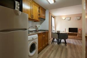 een keuken met een wasmachine, een tafel en een koelkast bij Santa Cruz in Broto