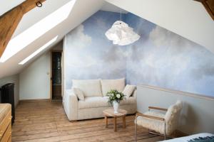 salon z kanapą i krzesłem w obiekcie Chez Agnès w mieście Pont-lʼÉvêque