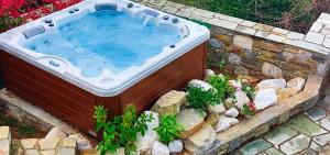 a large hot tub in a stone wall with rocks at A Dream Deferred villa Pelion in Kissós