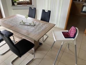 mesa de comedor y sillas con asiento para el corazón en Ferienwohnung Hubertus en Irsch