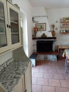 a kitchen with a fireplace and a table and a counter at Casa al mare in Massa