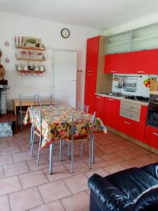 a kitchen with a table with chairs and red cabinets at Casa al mare in Massa