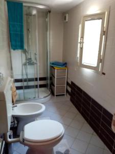 a bathroom with a toilet and a shower and a sink at Casa al mare in Massa