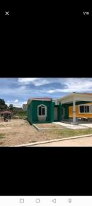 ein kleines grünes Gebäude mit einem Pferd auf dem Feld in der Unterkunft Tu mejor opción in Juticalpa
